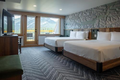 a hotel room with two beds and a television at Hotel Canoe and Suites in Banff