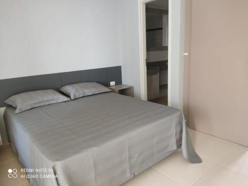 1 dormitorio con 1 cama grande y cabecero gris en Empresarial Jam flat em olinda, en Olinda