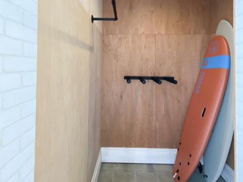 a room with a surfboard hanging on the wall at Pleasure Point Ichinomiya in Ichinomiya