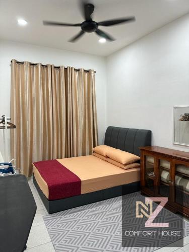 um quarto com uma cama e uma ventoinha de tecto em Nz comfort house pandan kuantan em Kuantan