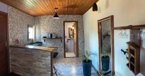 a living room with a kitchen with a brick wall at Chalé Recanto Dos Encantos in Lavras Novas