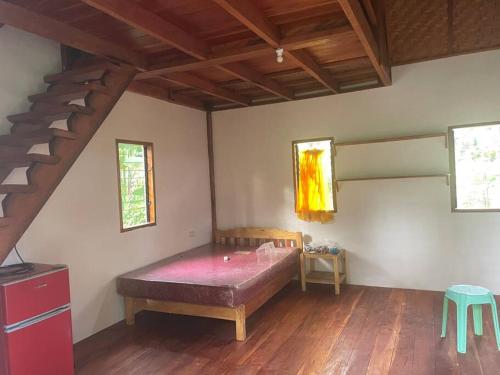 een slaapkamer met een bed en een trap in een kamer bij Jermaine quiet house in Lazi