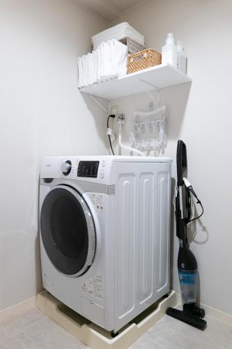 a washing machine in a room with a shelf at RIVER CENTRAL HIROSHIMA in Hiroshima