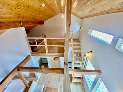 una escalera en una casa pequeña con techos de madera en Gassan Pole Pole Farm, en Nishikawa