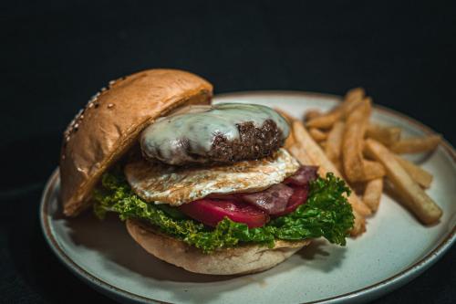 a white plate with a sandwich and french fries at Bali Summer Hotel by Amerta in Kuta