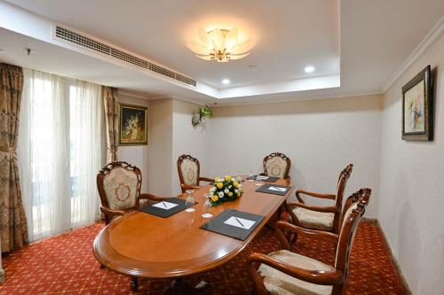 a dining room with a wooden table and chairs at Hotel Grand Saigon in Ho Chi Minh City