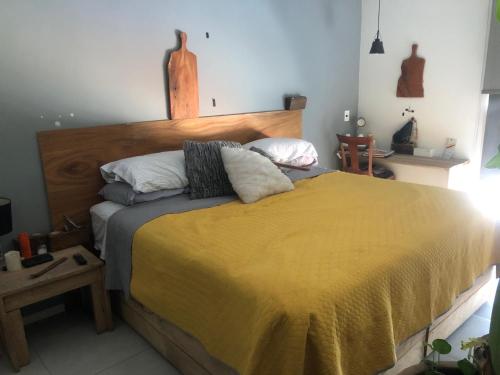 1 dormitorio con 1 cama grande con manta amarilla en Departamento de lujo exclusivo vistas y literas, en Guadalajara