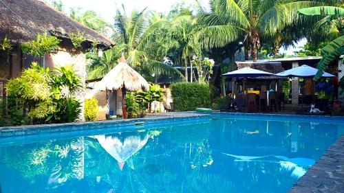 邦勞的住宿－蒂基島天堂度假村，棕榈树屋前的游泳池