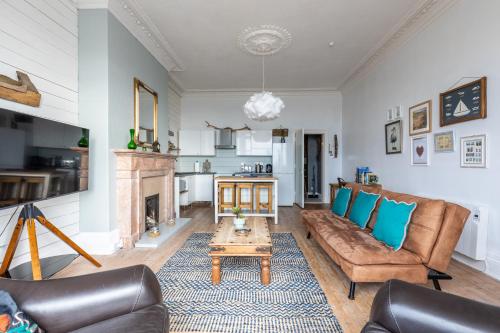 a living room with a couch and a table at Beach Lookout - SEA VIEWS in Lytham St Annes