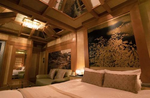 京都市にあるHotel Dion ホテル ディオン - Adult Onlyのベッドルーム1室(ベッド1台付)が備わります。壁には絵画が飾られています。