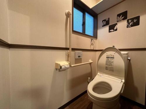 a bathroom with a toilet with the lid up at TasoneUrbanStayOsaka 梅田中津2 in Osaka