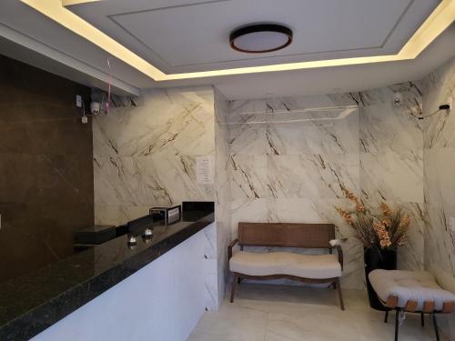 a lobby with a reception desk and marble walls at Hotel Cabana in Parauapebas