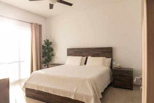 a bedroom with a large white bed and a window at Modern & relaxing penthouse Lake and Golf View in Punta Cana
