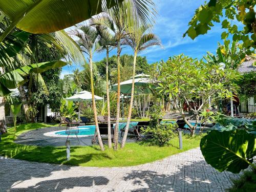 un complejo con piscina y palmeras en Rum Resort en Phu Quoc