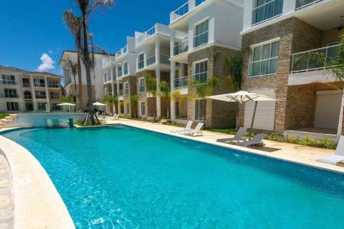 a swimming pool in front of a building at Modern & relaxing penthouse Lake and Golf View in Punta Cana