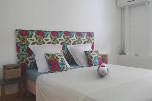 a white bed with pillows on top of it at LE SUNSET gîte côté canne in Grand-Bourg