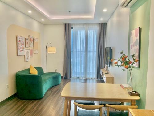 a living room with a green couch and a table at LAD Apartment & Homestay Hải Phòng - Hoàng Huy Grand Tower in Hai Phong
