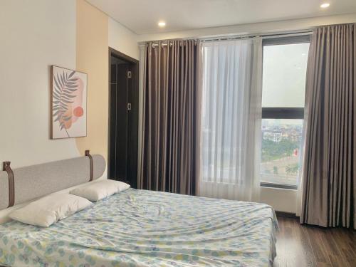 a bedroom with a bed and a large window at LAD Apartment & Homestay Hải Phòng - Hoàng Huy Grand Tower in Hai Phong