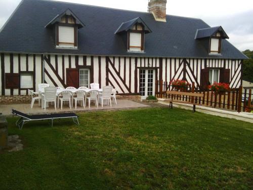 a house with white tables and chairs in front of it at Gite De Malvoue in Vimoutiers