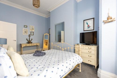 a bedroom with a bed and a tv on a dresser at Beach Shore - SEA VIEWS in Lytham St Annes