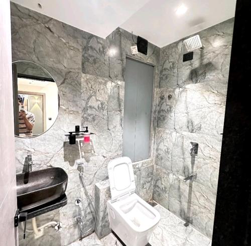 uma casa de banho com um WC, um lavatório e um espelho. em V Love Hotel em Surat