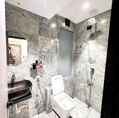 V Love Hotel في سورات: حمام به مرحاض أبيض ومغسلة