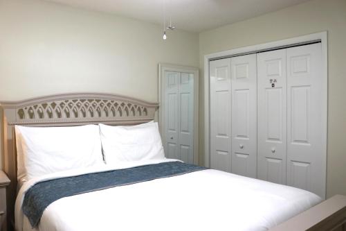 a bedroom with a white bed and a closet at Hidden Sapphire-Apartment with Kitchen and Laundry in Lakeland