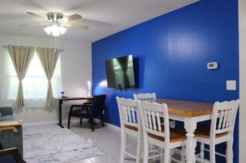 a dining room with a blue wall and a table and chairs at Hidden Sapphire-Apartment with Kitchen and Laundry in Lakeland