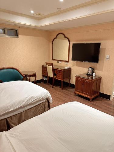 a hotel room with two beds and a flat screen tv at 爵起商務飯店 in Taoyuan