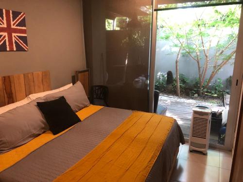 1 dormitorio con 1 cama con bandera en la pared en Departamento de lujo, exclusivo Terraza y jardín gh02, en Guadalajara