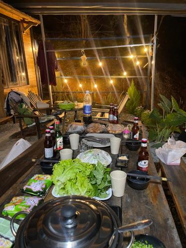 a table topped with plates of food and vegetables at Lâm Bích Homestay & Coffee in Ấp Phước Thánh