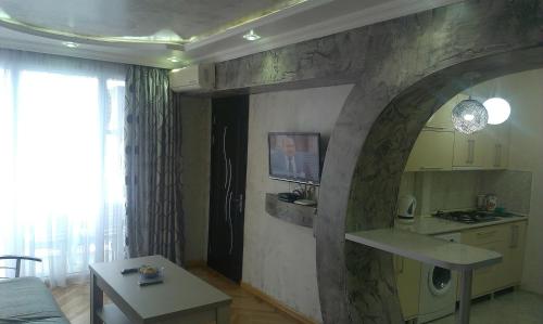 cocina y sala de estar con pared de piedra en Irakli's Apartment with Sea view, en Batumi