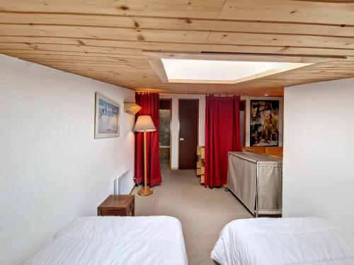 a bedroom with two beds and red curtains at Appartement Val-d'Isère, 3 pièces, 6 personnes - FR-1-518-147 in Val-d'Isère