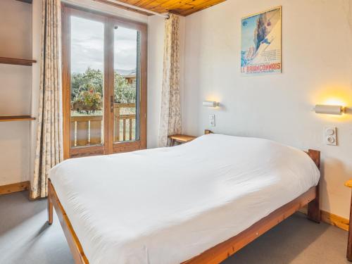 une chambre avec un grand lit et une fenêtre dans l'établissement Appartement 2 pièces avec coin montagne, balcon, piscine estivale, à 300m des pistes à Serre Chevalier - FR-1-762-7, à Saint-Chaffrey