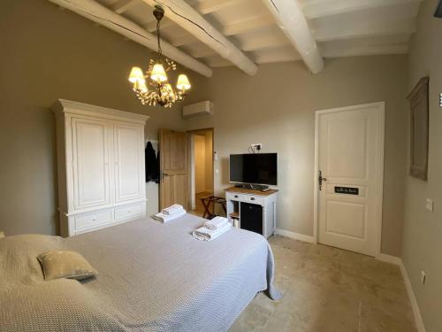 - une chambre avec un lit, une télévision et un lustre dans l'établissement Villa Saumane-de-Vaucluse, 7 pièces, 10 personnes - FR-1-767-9, à Saumane-de-Vaucluse