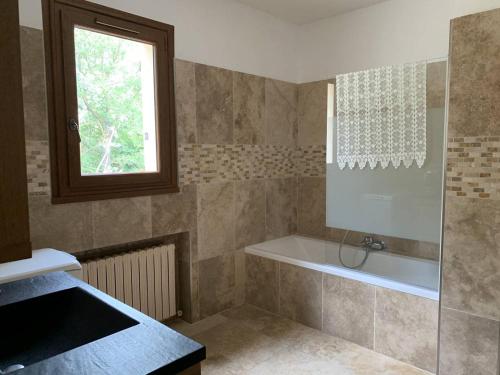 een badkamer met een bad en een raam bij Maison Saumane-de-Vaucluse, 4 pièces, 6 personnes - FR-1-767-10 in Saumane-de-Vaucluse