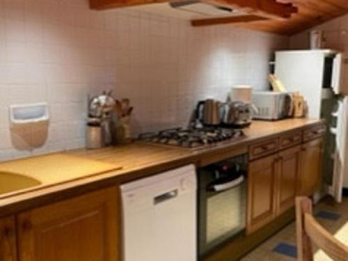 une cuisine avec une cuisinière et un comptoir dans l'établissement Grand appartement 5 chambres - Proche centre, balcon sud, Wi-Fi et parking inclus - FR-1-671-251, aux Gets