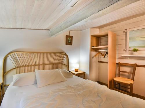 une chambre avec un lit blanc et une chaise dans l'établissement Appartement T3+chambrette 6 pers, centre Les Gets, proche pistes - FR-1-685-75, aux Gets