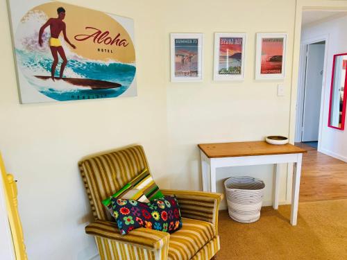 a living room with a chair and a picture of a surfer at Lo Quay - Pet Friendly (small pets approved inside in Robe