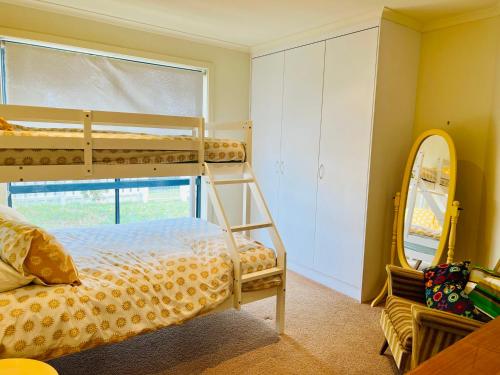 a bedroom with two bunk beds and a mirror at Lo Quay - Pet Friendly (small pets approved inside in Robe