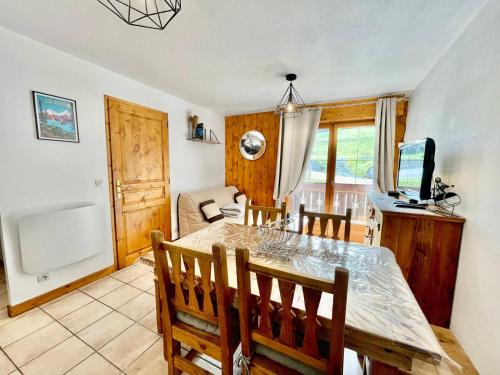 une salle à manger et un salon avec une table et des chaises dans l'établissement Appartement charme pieds des pistes avec terrasse et WIFI inclus - FR-1-505-197, à Notre-Dame-de-Bellecombe