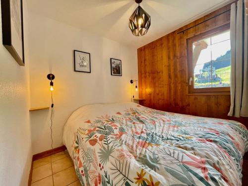 - une chambre avec un lit doté d'un couvre-lit coloré dans l'établissement Appartement charme pieds des pistes avec terrasse et WIFI inclus - FR-1-505-197, à Notre-Dame-de-Bellecombe