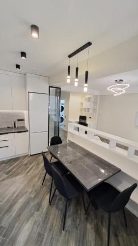 a kitchen and dining room with a table and chairs at Аэропорт Кишинев 24&24 in Chişinău