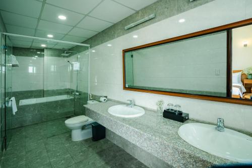 a bathroom with two sinks and a large mirror at Bombo DaLat Hotel in Da Lat