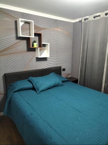 聖安東尼奧的住宿－Alojamientos Barrancas，一间卧室配有一张带蓝色床罩的床