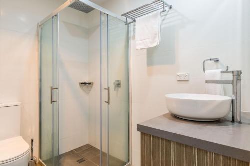 a bathroom with a sink and a glass shower at Ishtar Apartment 8- Luxury Studio in Huskisson