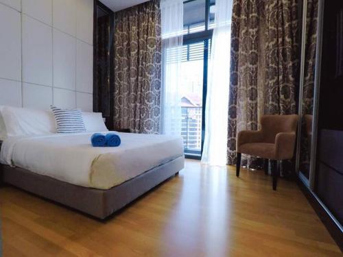 a bedroom with a bed with two blue towels on it at Dorsett Bukit Bintang Pavilion in Kuala Lumpur