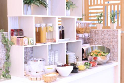 a shelf filled with dishes and plants in a kitchen at KOKO HOTEL Sendai Station South in Sendai