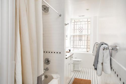 biała łazienka z zasłoną prysznicową i toaletą w obiekcie Sleepover No 104 w Filadelfii