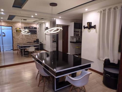 Apartamento com vista para piscina في Cataguases: مطبخ وغرفة طعام مع طاولة وكراسي
